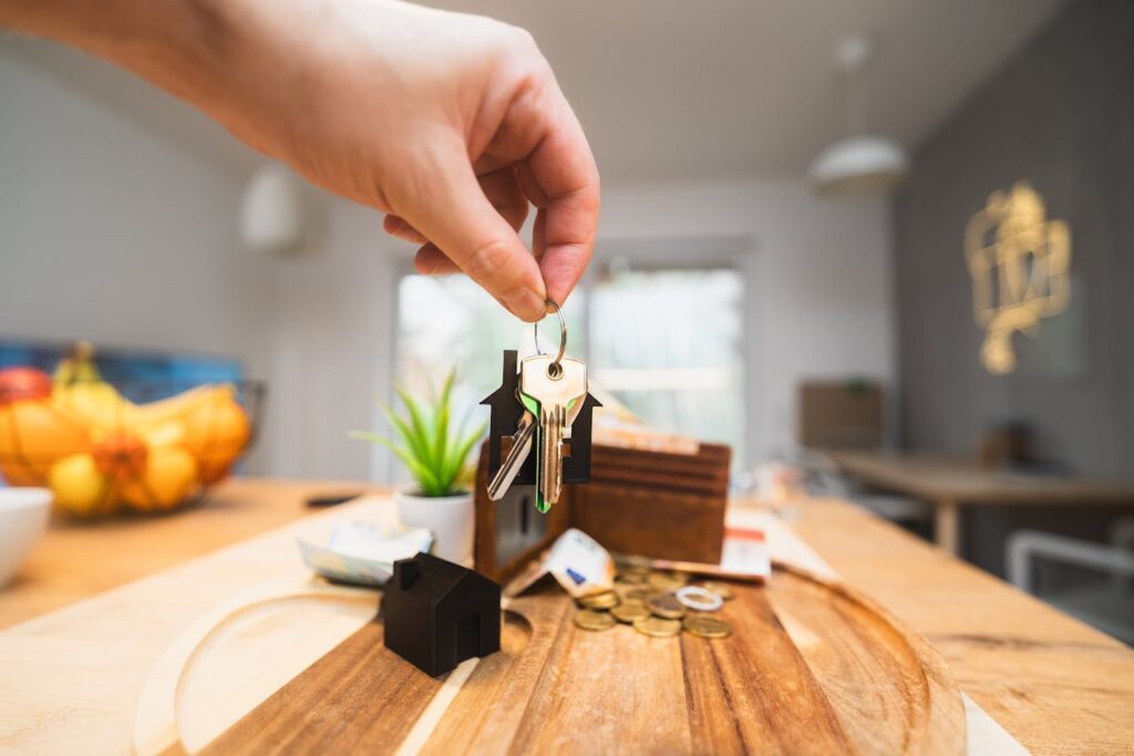 pexels photo 29726512 Hand holding keys in a modern living room setting, symbolizing home ownership or real estate investment.