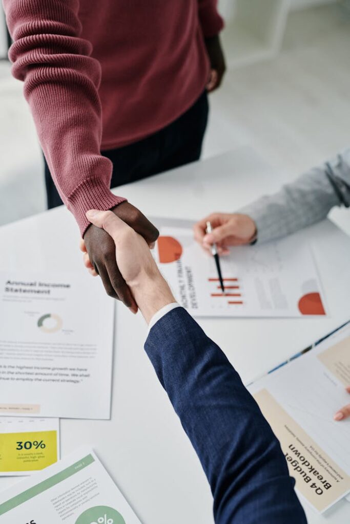 pexels photo 7109289 Professional handshake over financial documents symbolizes successful business partnership and teamwork.